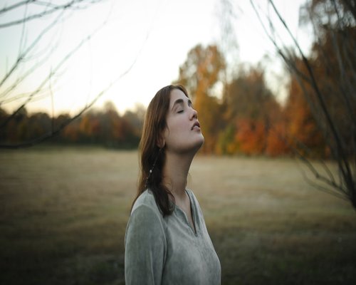 Woman taking a relaxing deep breath outdoors